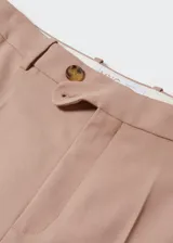 Pantalón de vestir color beige, de corte recto y tiro alto. Confeccionado en mezcla de lana con forro interior, cierre oculto de botón, gancho y cremallera, y dos bolsillos laterales.