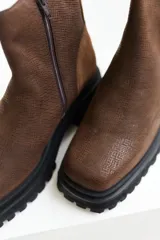 Botas de cuero negro con punta cuadrada, caña media y cierre lateral con cremallera.