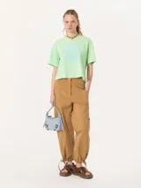 Remera rosa de algodón pima con estampado circular en el frente con la frase 'You Should Be Dancing' y un personaje bailando. Tiene corte amplio, mangas cortas, cuello redondo y tajos laterales.