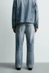 Jeans de denim de algodón, tiro medio, con pierna recta y ajuste relajado. Presentan un efecto lavado claro y cierre frontal con botones.