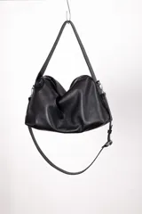 Bolso tipo hobo color borgoña, de cuero con textura granulada. Tiene correa de hombro ajustable y extraíble, cierre superior con cremallera, forro interior de algodón con bolsillo con cremallera y bolsillo abierto.