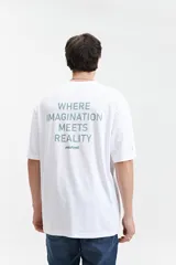 Remera blanca de manga corta con corte oversize, cuello redondo y estampado en la espalda con la frase "WHERE IMAGINATION MEETS REALITY" y el logo de la marca Mistral.