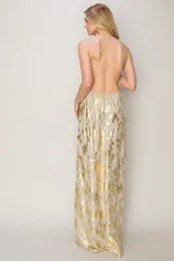 Vestido largo de fiesta color champagne con estampado dorado, breteles finos y escote en V.