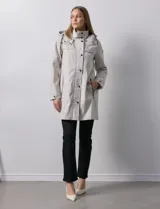 Gabardina impermeable negra, marca Weatherproof, con cierre central oculto y botones a presión. Tiene bolsillos delanteros con cierre, capucha no desmontable y forro interno de abrigo desmontable.