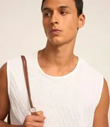 Musculosa blanca de poliéster con elastano, corte regular y textura diagonal.