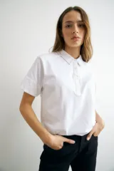 Remera azul marino de algodón con cuello polo, manga corta con detalle de broderie y tapeta con botones.