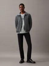 Campera bomber gris de nailon reciclado, con cuello alto, cierre de cremallera, bolsillos laterales y puños y bajo elásticos.