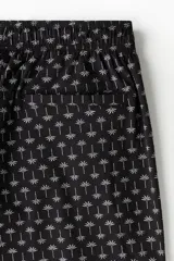 Traje de baño negro con estampado de palmeras blancas, con elástico y cordón en la cintura, bolsillos laterales y trasero con cierre autoadherente.