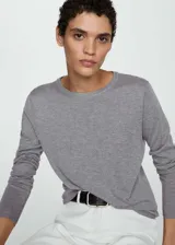 Buzo de punto fino color gris, con cuello redondo y mangas largas.