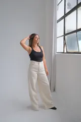 Jean de corte wide leg en color crudo, con tiro alto y costuras reforzadas en contraste. Presenta diseño de cinco bolsillos y cierre frontal con botón metálico.