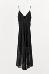 Vestido midi negro de tirantes finos con escote fluido y detalle de abalorios en el corpiño. Falda asimétrica con volados. Forro interior.