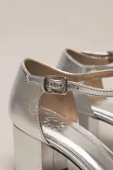 Zapato de vestir negro de cuero, con punta fina, tira en forma de T y hebilla lateral.