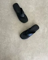 Ojotas negras con base cuadrada y tiras blancas.