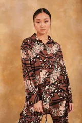 Camisa marrón con estampado de tigres y manchas de leopardo, de corte holgado y mangas largas.