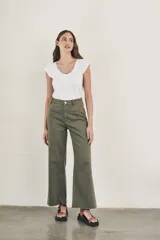 Pantalón wide leg color beige, de tiro alto, ligeramente ajustado en cintura y con ruedo desflecado.