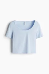 Remera cropped celeste con escote amplio en U y mangas cortas. De punto acanalado fino de algodón y ajuste entallado.