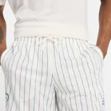Short deportivo blanco con finas rayas verticales azules y logo bordado en azul en la pierna izquierda.