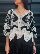 Camisa negra con detalles de crochet color crema, escote en V y mangas 3/4.