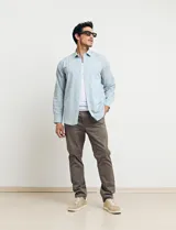 Pantalón de vestir verde medio, de corte recto, con bolsillos laterales y traseros.