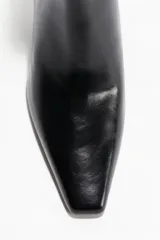 Botines cortos de cuero negro con acabado brillante, punta cincelada y taco fino.