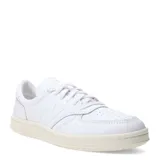 Championes urbanos New Balance Court, color blanco con detalles en beige, confeccionados en cuero, con logo "N" característico en los laterales y suela de goma.