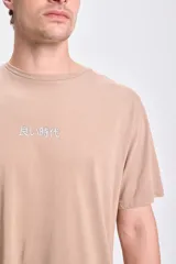 Camiseta de manga corta color taupe con estampa de gato de la suerte japonés en la espalda.