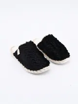 Pantuflas cerradas de piel sintética color negro con forro de felpa color crema.