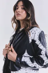 Campera de cuero sintético negra con apliques blancos y tachas plateadas.
