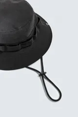 Sombrero tipo bucket negro de algodón con cinta multifunción y ala ancha con pespuntes. Ajuste con cordón.