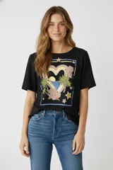 Remera negra de algodón con estampado de un corazón con palmeras, estrellas y flores.