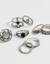 Set de 8 anillos plateados con detalles en bajo relieve y apliques símil piedra.