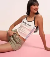 Top frente única color crema con estampado de texto "Stanley Park" en azul marino y ribetes negros.