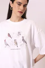 Remera negra de corte oversize con estampado abstracto en tonos rojos, grises y blancos.
