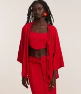 Kimono alargado color rojo, confeccionado en viscosa y lino. Tiene mangas largas y abertura frontal total con detalle de cuerdas dobles.