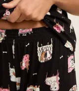 Conjunto de pijama americano largo, confeccionado en viscosa estampada con diseño de perros. Incluye una camisa de manga corta con cuello y botones, y un pantalón largo con cintura elástica.