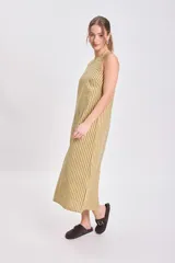 Vestido midi sin mangas, de corte recto y holgado, con cuello redondo. Presenta un estampado de rayas verticales finas en tonos amarillo claro y verde oliva/marrón.