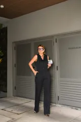 Conjunto de chaleco y pantalón negro con finas rayas verticales blancas. El chaleco es entallado, con escote en V y cierre frontal con botones. El pantalón es de corte palazzo.