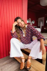 Sweater oversize de punto con rayas horizontales en colores azul, verde y lila. Tiene cuello polo blanco con cartera de botones.
