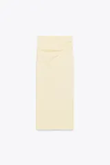 Falda midi color crema, de tiro alto con cintura elástica y detalle de pliegues laterales.