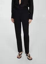 Pantalón de vestir azul marino, de corte recto, con bolsillos laterales y traseros. Se ajusta a la cintura con cinturón de cuero marrón.