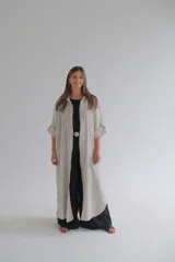 Camisola larga a rayas verticales color beige y blanco, confeccionada en lino 100%. Tiene mangas 3/4 con botón ajustable.