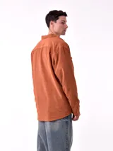 Sobrecamisa marrón de pana con cuello clásico, cierre frontal con botones a presión, dos bolsillos de parche con solapa abotonada en el pecho y corte holgado.