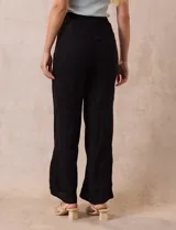 Pantalón negro de rayón con bordados florales, pretina ancha elastizada en punto smock y corte palazzo. Marca Liv Los Angeles.