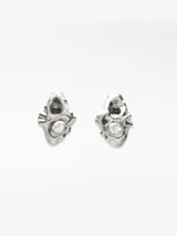 Pendientes metálicos con diseño en relieve de forma orgánica, decorados con una perla natural y una cuenta oscura. Poseen cierre de broche.