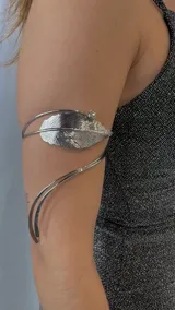Brazalete plateado para brazo con diseño de hoja y detalle de strass.