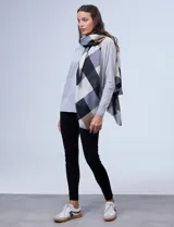 Pashmina estampada a cuadros colorblock en tonos de negro, gris, blanco y marrón claro.