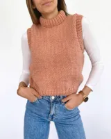 Chaleco tejido a mano color salmón, con cuello alto y sisas amplias.