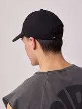 Gorra de lona color salmón con logo de la marca bordado en blanco.