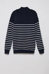 Sweater de punto azul marino con rayas horizontales blancas, cuello alto con cierre de medio cierre y mangas largas.