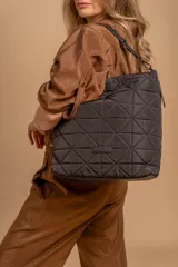 Bolso tipo shopper color beige con diseño acolchado geométrico y correa de hombro negra.